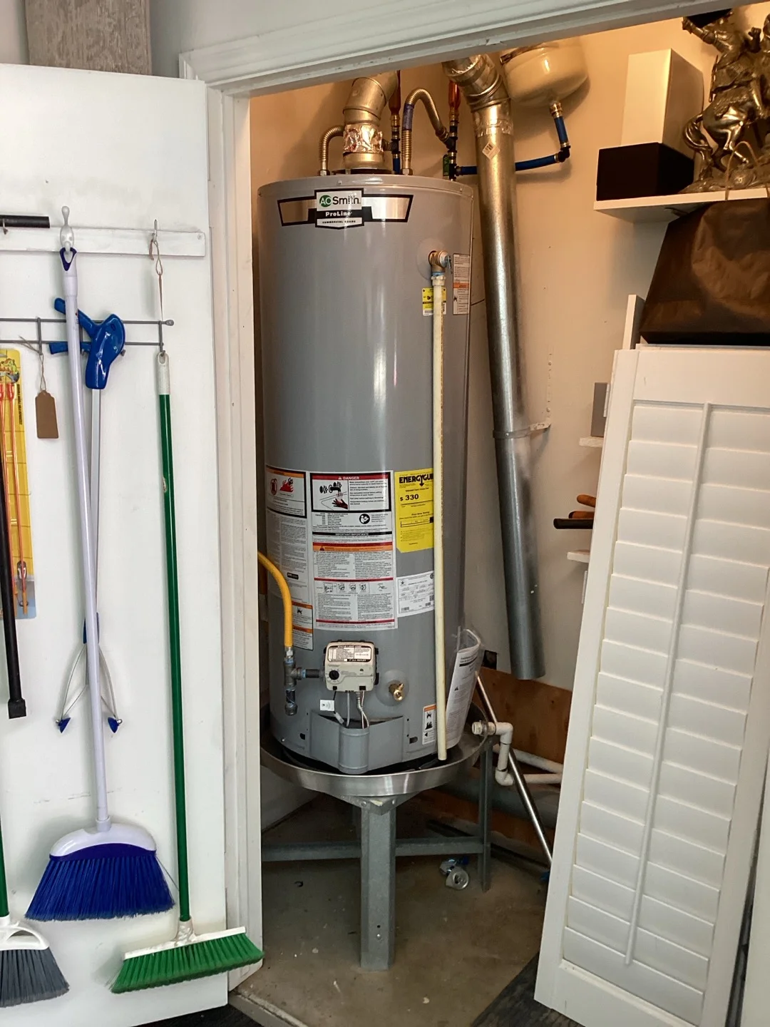 Storage-tank water heater with a drain pan and accessible lower plumbing connections