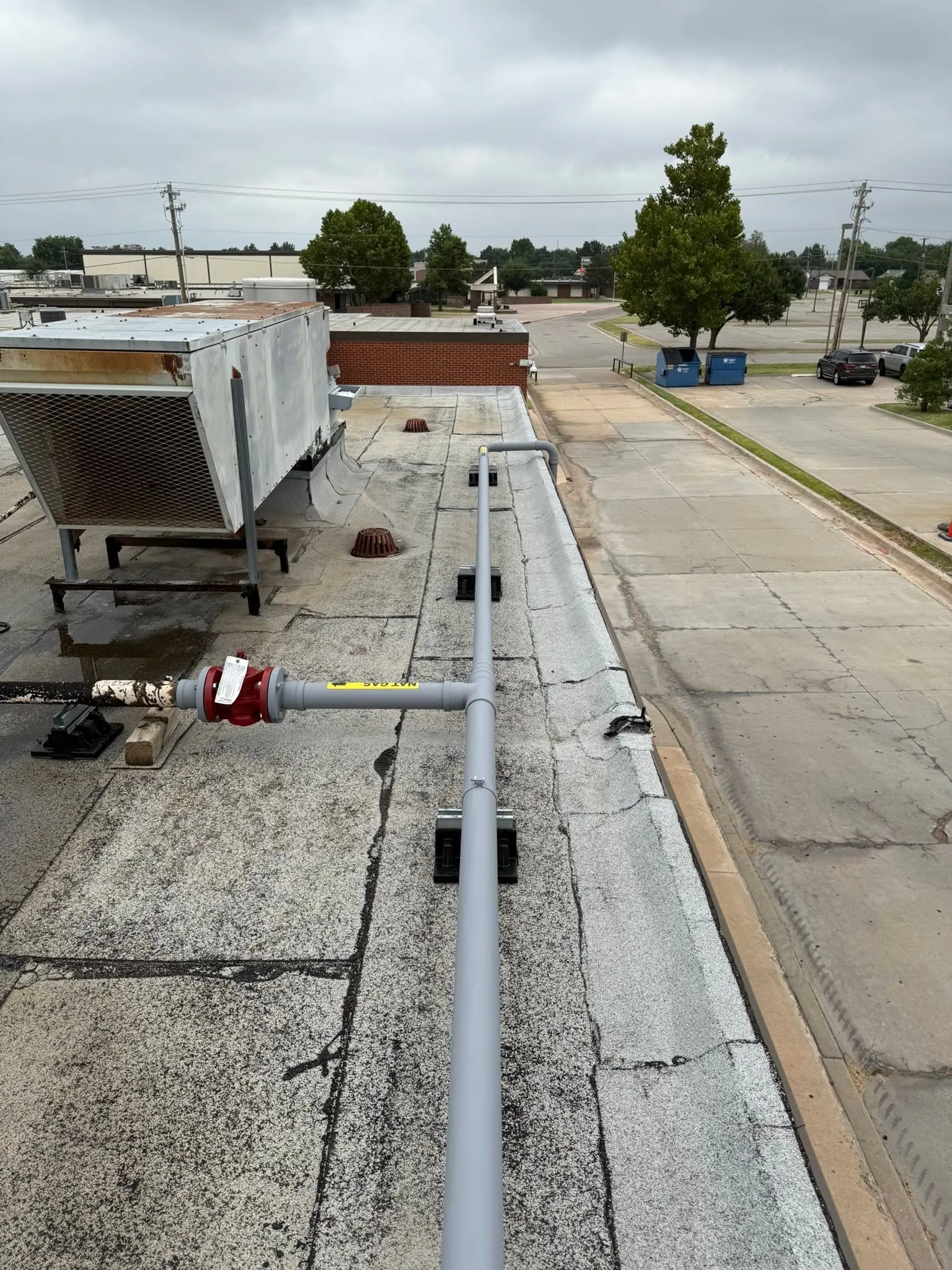 Code-compliant rooftop natural gas line with support blocks and labeling